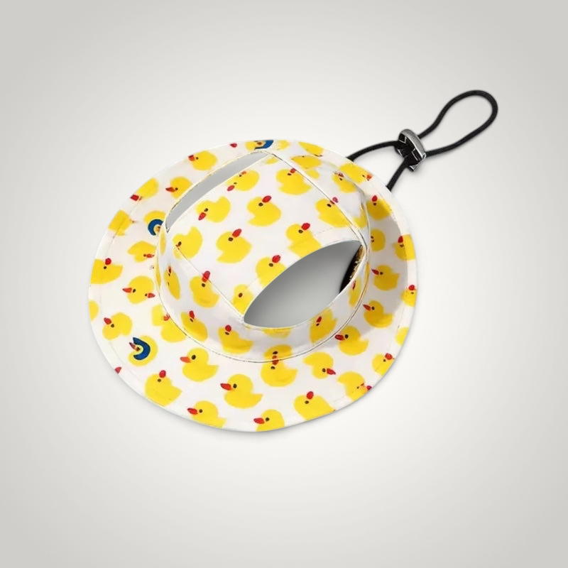 HappiFinds dog sun hat in white with a yellow rubber duck pattern, featuring ear holes and an adjustable chin strap.