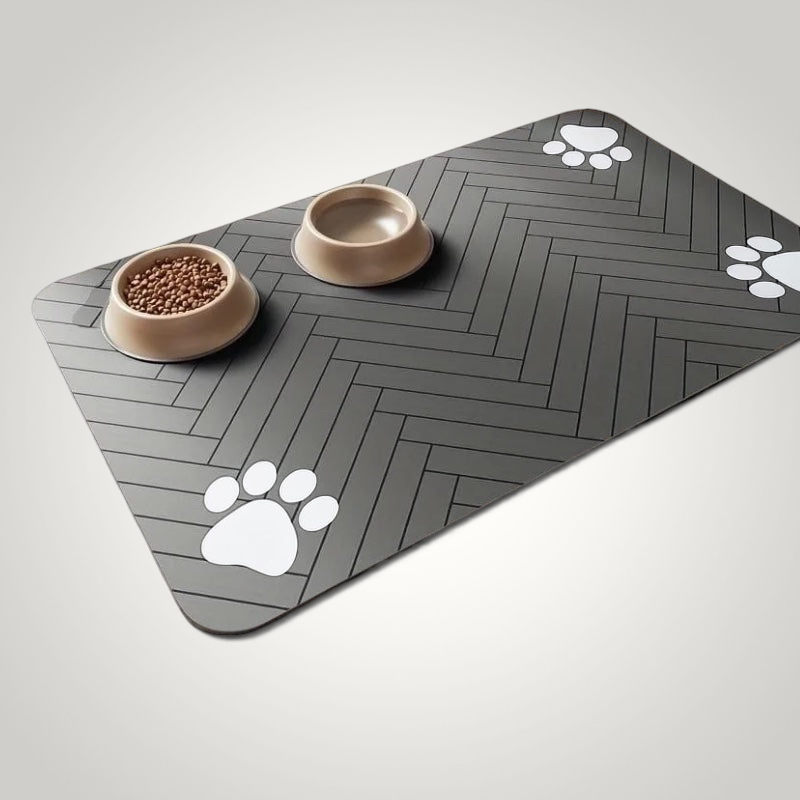 HappiFinds dark gray waterproof dog feeding mat with herringbone pattern and white paw print accents under two bowls.