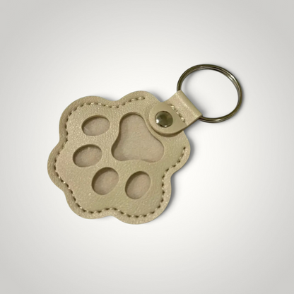 HappiFinds beige faux leather paw-print dog hair collector keychain with a sturdy metal ring for pet owners.