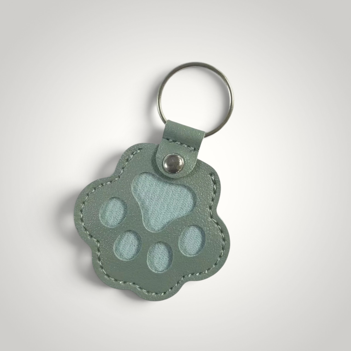 HappiFinds sage green faux leather paw print dog hair collector keychain with a sturdy metal ring.
