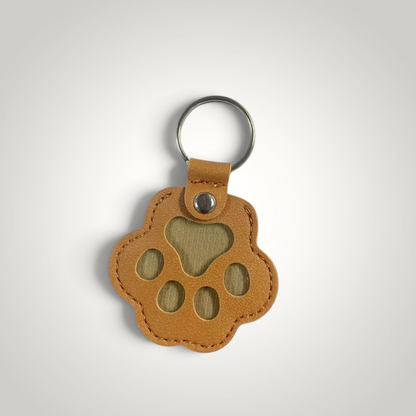 HappiFinds tan faux leather paw-print dog hair collector keychain with a metal ring for portable lint removal.