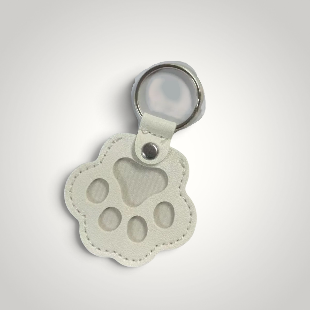 HappiFinds white faux leather paw-print dog hair collector keychain with a metal ring for portable lint removal.